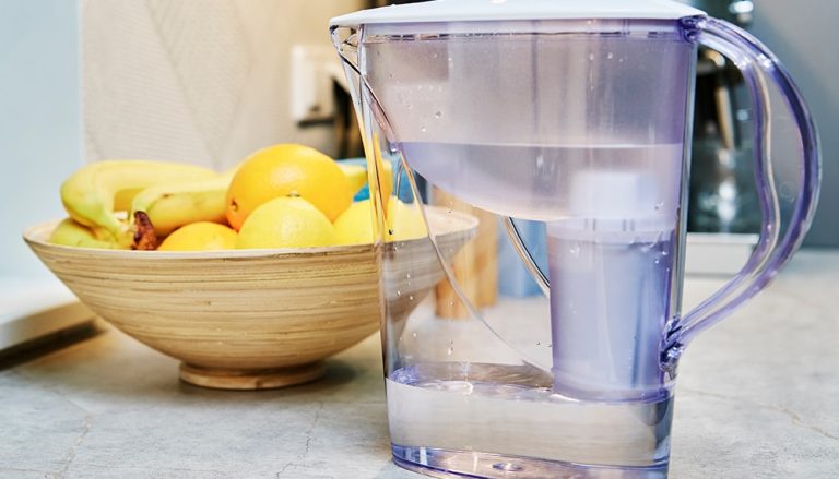 Pichet filtrant rempli d'eau sur un comptoir de cuisine