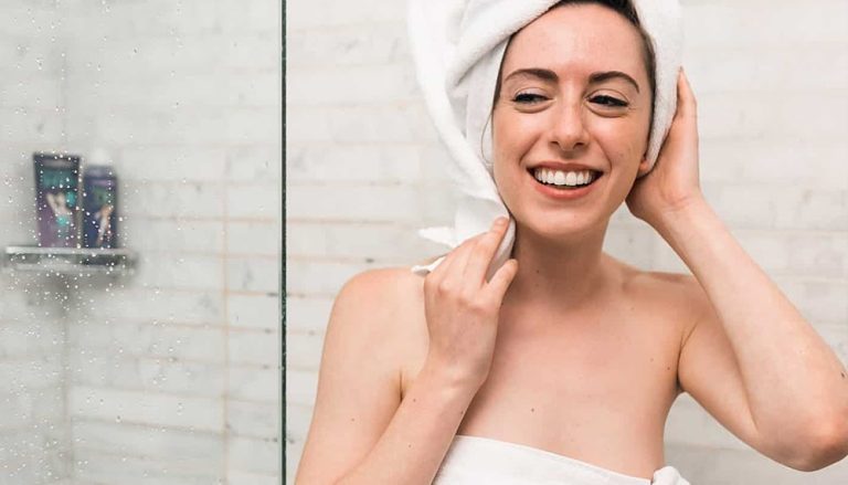 Femme après la douche : les effets de l'eau dure sur la peau et les cheveux