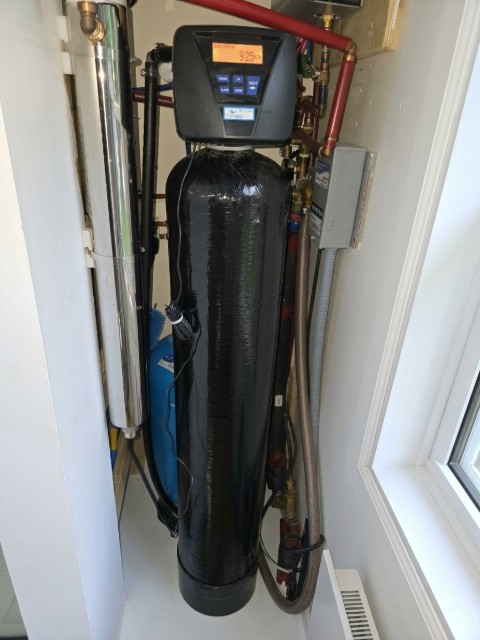 Système de traitement d'eau installé par Pure H2O : filtre à rétrolavage, stérilisateur UV et réservoir sous pression